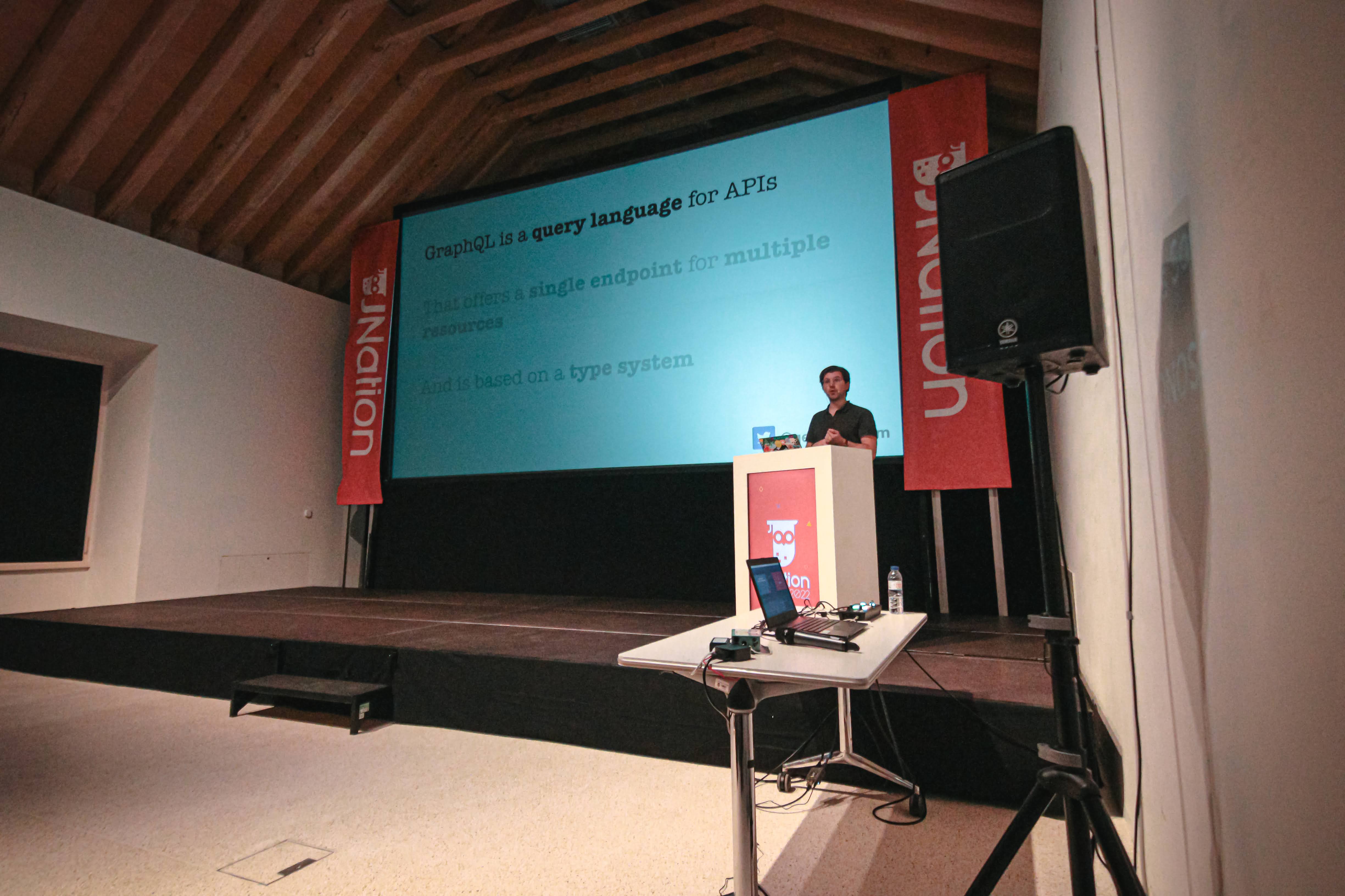 Roy Derks presenting Why GraphQL Is Perfect For Microservices on stage at JNation 2022